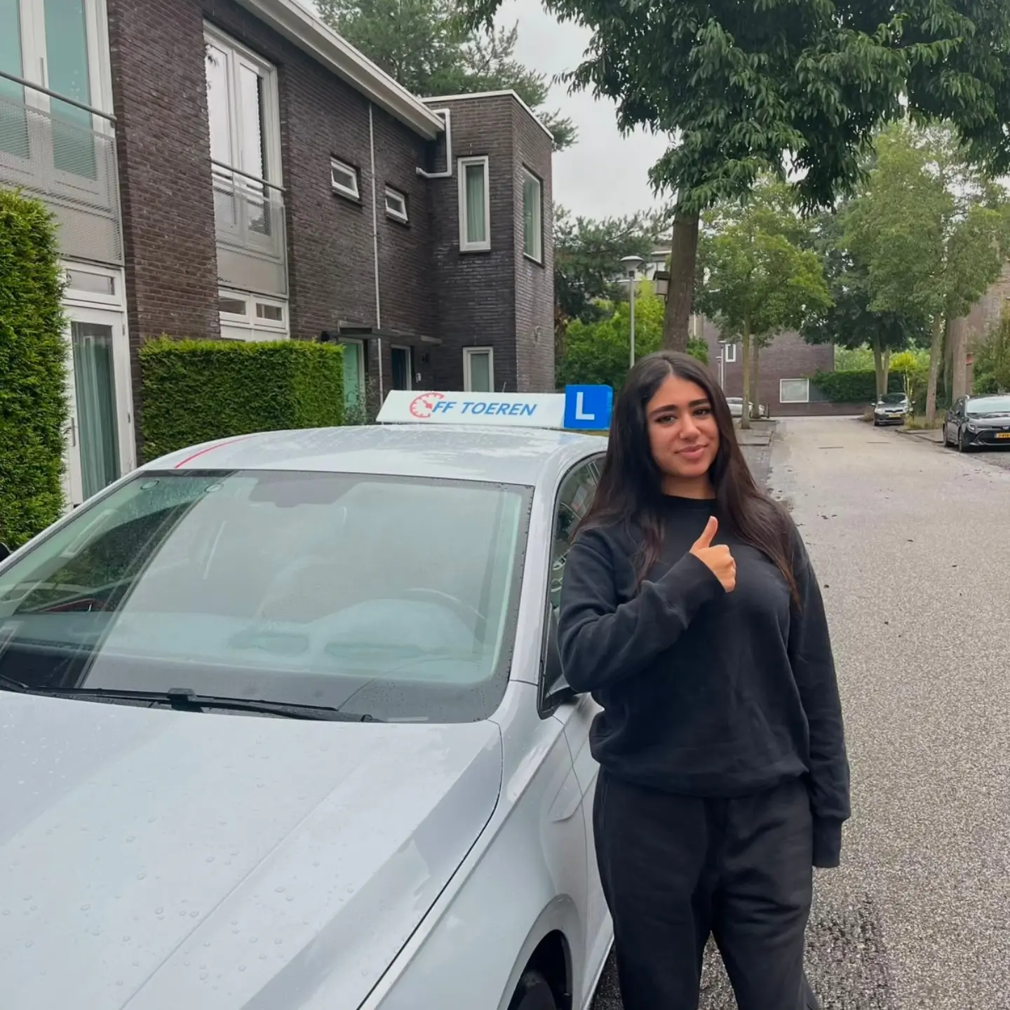 Geslaagde leerling van Rijschool FF Toeren bij de lesauto in Zwolle